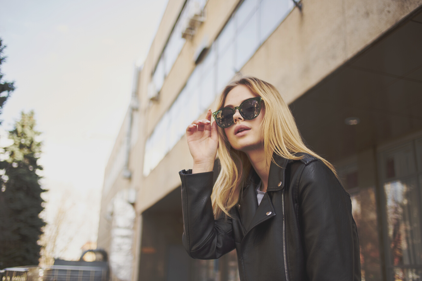 Fashionable Woman in Sunglasses Blond Building Leather Jacket